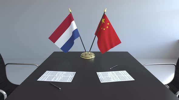 Flags of the Netherlands and China on the Table