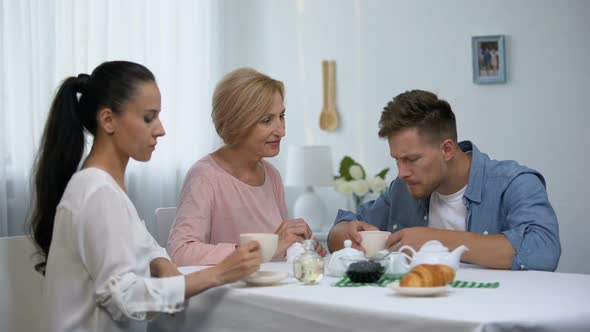 Shocked Women Looking at Mother-In-Law Wiping Sons Mouth During Having Coffee