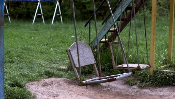 Empty old swinging swing in the playground