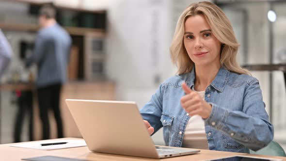 Positive Young Woman with Laptop Showing Thumbs Up