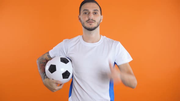  Soccer Ball in Font of White Blue Shirt Soccer Fan Smiling and Succes 