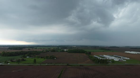 Aerial forwarding shot of farms on a cloudy moody day in Canada