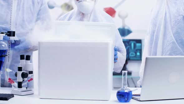 Team of Chemist Scientists Opening a Refrigerator Box in a Modern Research Laboratory