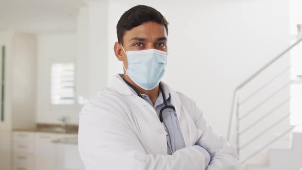 Portrait of hispanic male doctor at home, all wearing face mask