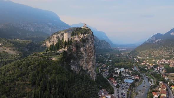 Picturesque old Arco castle on cliff above Riva del Garda city, Trentino, Italy. Aerial view of anci