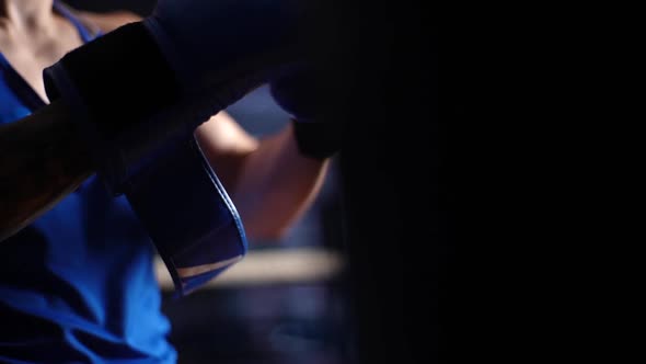 Closeup Cropped Shot of Unrecognizable Boxer Male Putting on Boxing Gloves in Sport Club with Dark