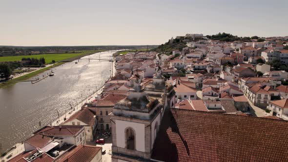 Beautiful rooftops of Alcacer Do Sal town on Sado river coastline, aerial orbit view