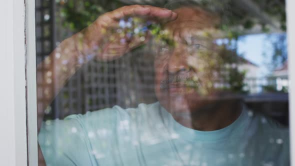 Senior mixed race man sitting on bed looking away