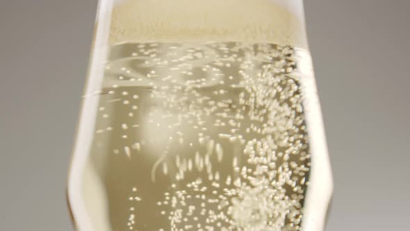 Bubbles in a Glass of Champagne on a White Background Close Up