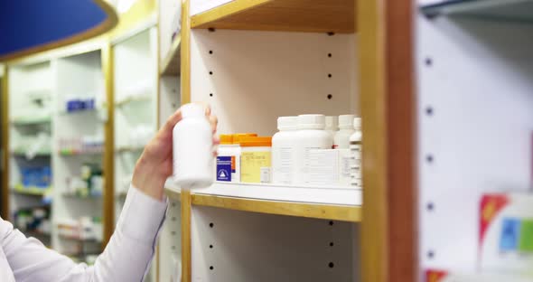 Pharmacist checking a bottle of drug