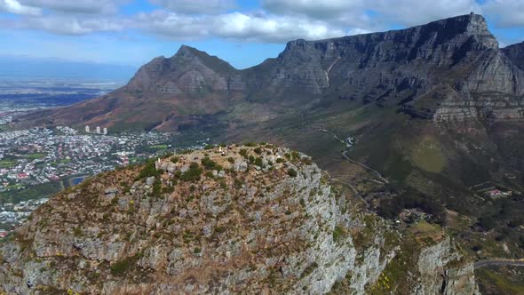 Drone shot of Lions Head in Cape Town - it is circling around the top of Lions Head, facing Table Mo