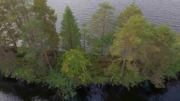 Aerial footage of a narrow island in a lake in Finland.