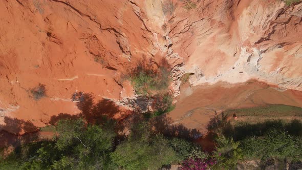 Aerial Slowmotion Shot of a Red Canyon or Fairy Stream at the Border of Desert in the Mui Ne Village