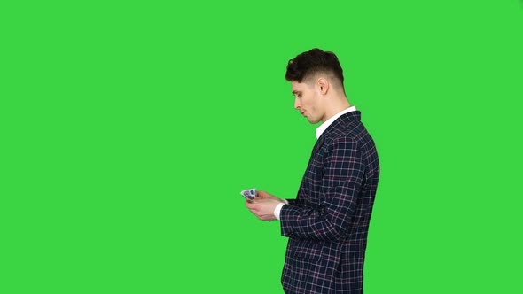 The Man in Formal Outfit Walking in Counting Money on a Green Screen, Chroma Key.