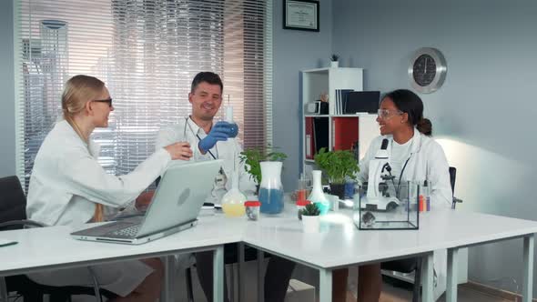 Happy Multiracial Team of Scientists Making Toasts with Dry-ice Cocktails in Flasks