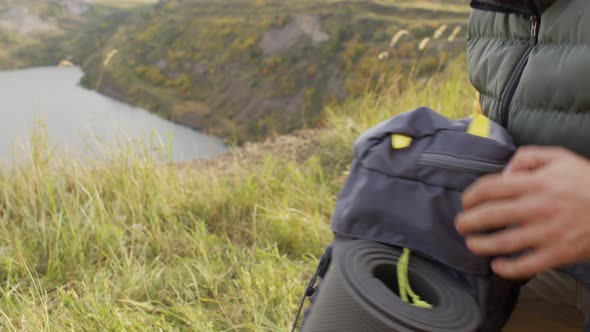 Man Taking Tent Bag Out of Backpack on Hike