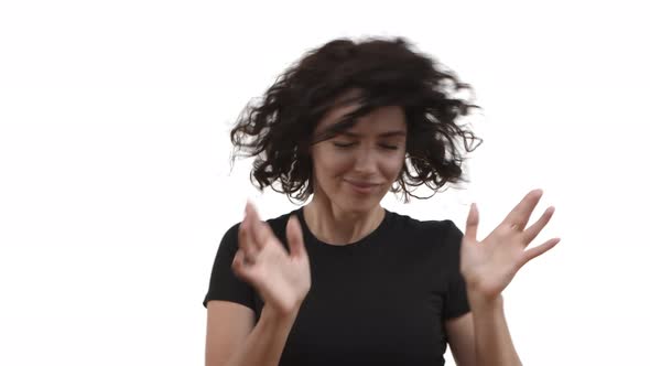 Attractive Carefree Woman with Short Curly Hair Wearing Casual Black Tshirt Dancing and Shaking Head