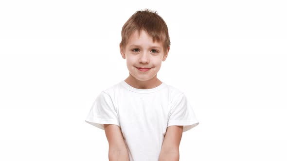 Embarassed Elementaryschool Aged Boy Standing on White Background Smiling and Showing Tongue