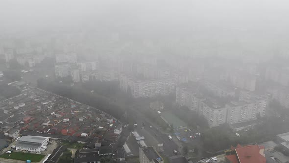 Aerial View of Dense Cityscape Slowly Ascending Through Clouds