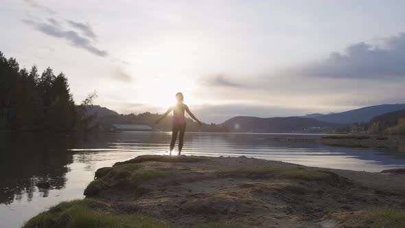 Adventurous Woman on a Shore Enjoying Colorful Sunset