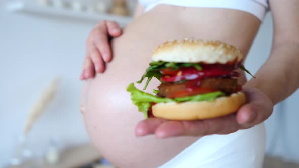 Healthy Alternatives To Unhealthy Food. Pregnant Woman Holding Vegan Burger