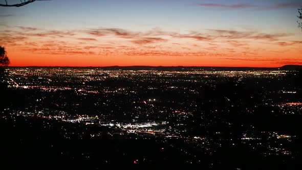 Gorgeous dusk sunlight along horizon showing city as a timelapse of traffic moving around city with alt
