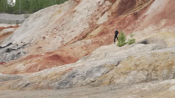 Tourist in bright sunny day on red canyon Man is walking in the mountains Ural Mars