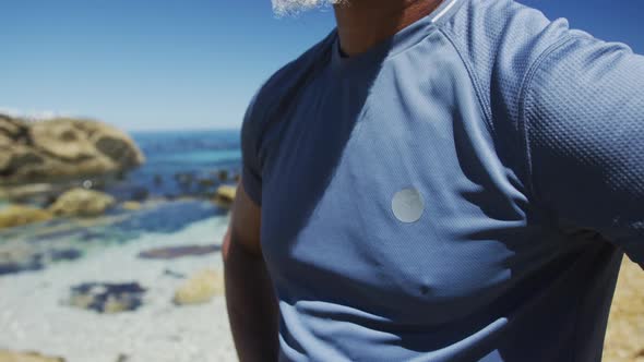 Senior african american man taking a break during exercise, admiring the seaview