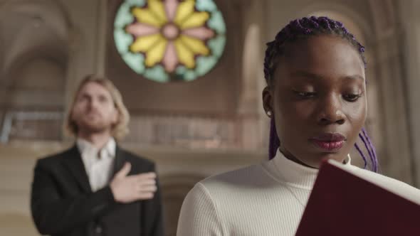 Two Diverse Parishioners Praying in Christian Church