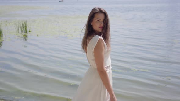 Portrait Charming Young Girl with Long Brunette Hair Wearing a Long White Summer Fashion Dress