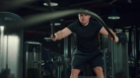 Man Exercising with Battle Ropes in Gym