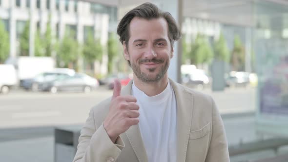 Thumbs Up By Young Man Standing Outdoor