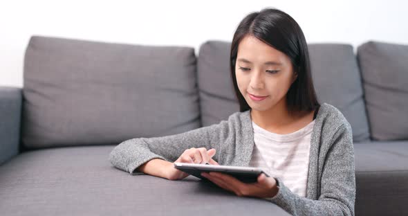 Woman using tablet computer at home