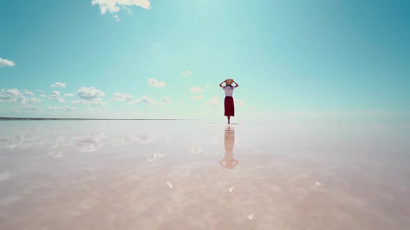 Rear View Woman in Straw Hat Enjoying Beautiful Nature at Pink Salt Lake