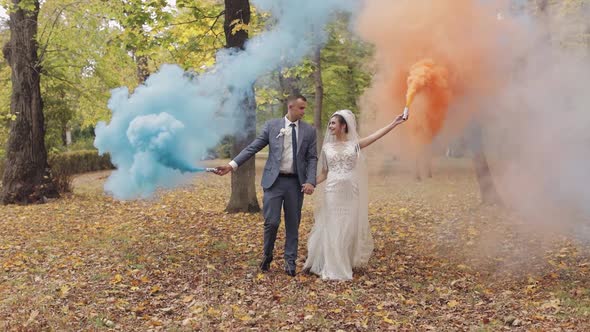 Caucasian Groom with Bride in the Park. Wedding Couple. Smoke Bombs. Newlyweds