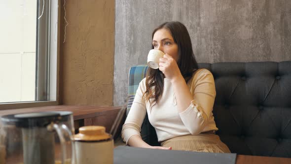 Young Beauty Romantic Woman Drinking Hot Tea or Coffee at Cafe