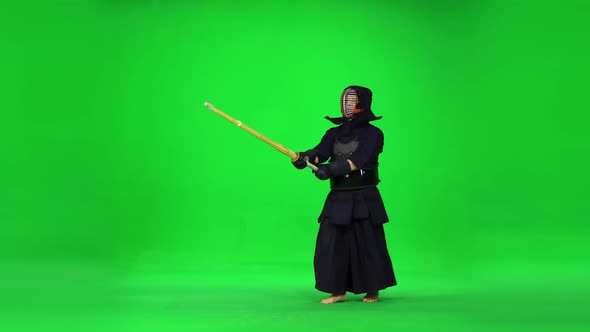 Masculine Kendo Warrior Practicing Martial Art with the Bamboo Bokken on Green Screen.