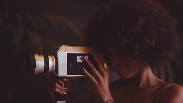 Woman With Afro Hair Using Vintage 8Mm Camera