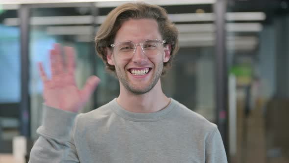 Portrait of Young Businessman Waving Welcoming