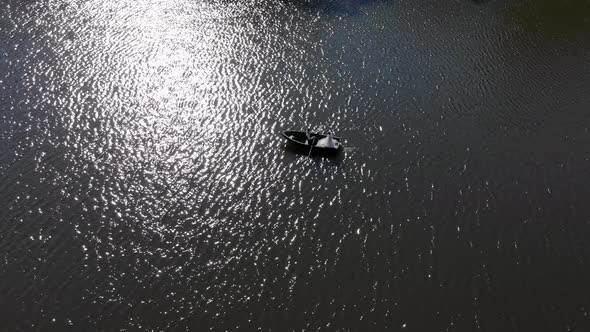 Boat with Brides on the Background of the Fabulous Glare of the Sun, Which Is Reflected in the Water