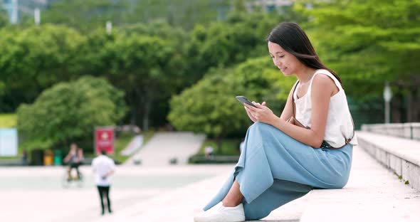 Asian woman use of mobile phone in city