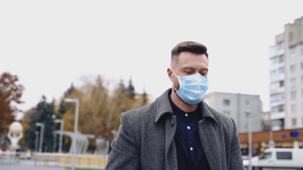 Young businessman is posing outdoor with a strong expression and facial mask.