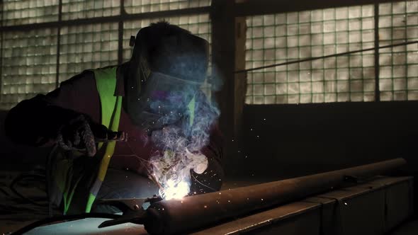 Close Up View of Factory Worker Welds Metal Using a Welding Machine