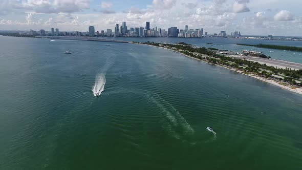 Aerial shot of boats traveling in Key Biscayne with the downtown Miami Skyline in the background