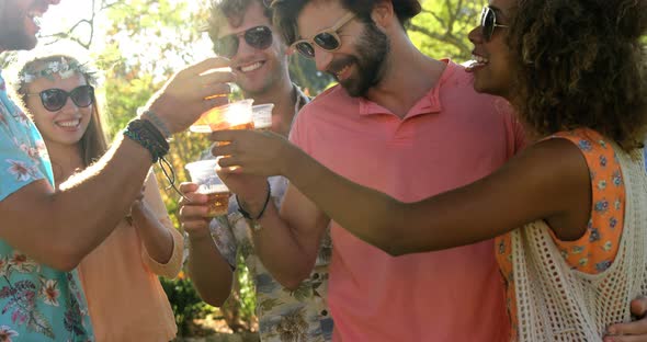 Group of hipster friends toasting with glasses of beer