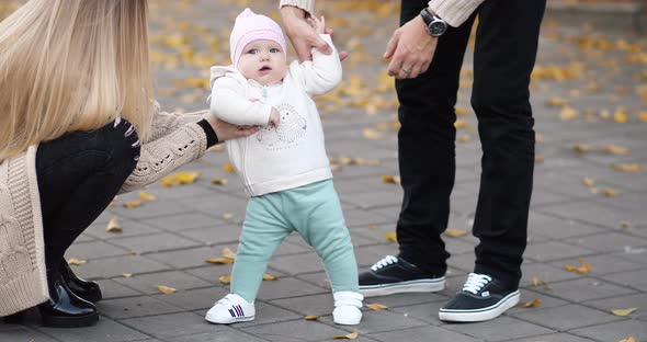 Happy Baby Learning To Walk in Autumnal Park