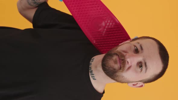 Vertical Video Medium Closeup of Young Caucasian Man with a Tattoo on His Face Holding Red