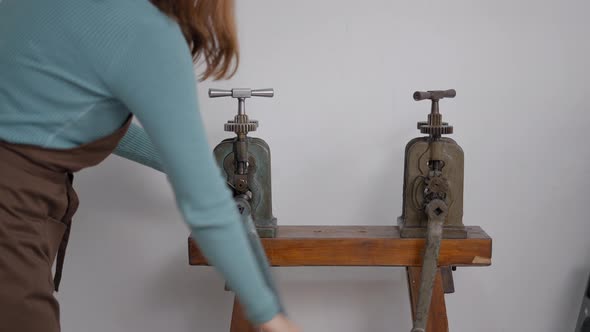 Female Artisan Uses Rolling Mill Machine To Imprint Pattern On Metal Sheet At Workshop