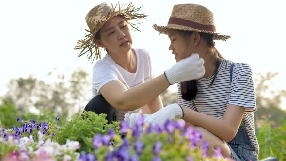 Slow motion Happy Asian mother and daughter planting flower together in the garden.