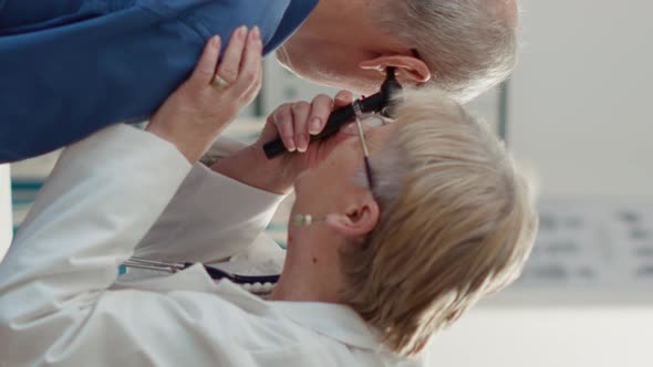 Vertical Video Otolaryngology Specialist Using Otoscope to Examine Ear Infection